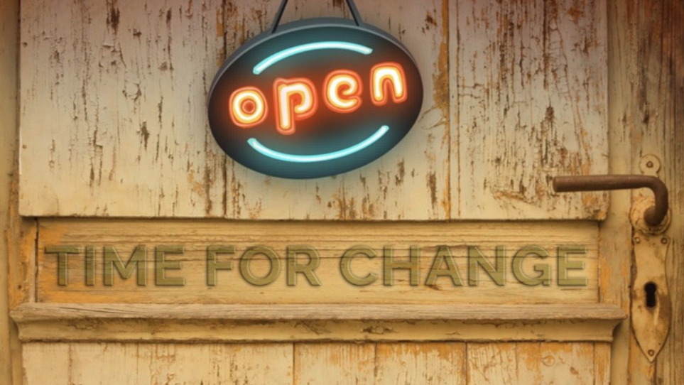 It's Time For Change neon sign on a wooden door