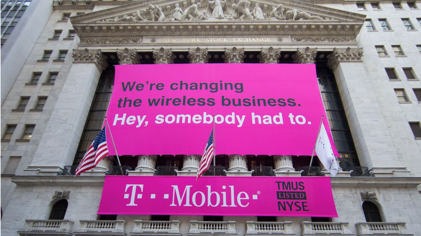 Pink T-Mobile sign on a tall cement city building 